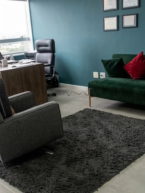 Sala de atendimento com sofá, poltrona e mesa